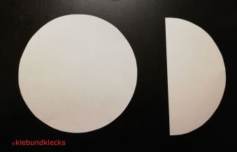 Zwei Kreise aus Papier, einer in der Mitte gefaltet
