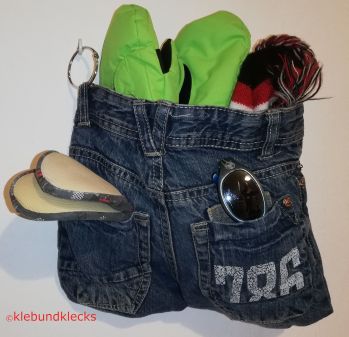 Garderobenbeutel aus Jeans gefüllt mit Handschuhen, Schal und Haube