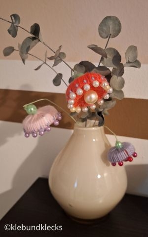 Blumen aus Wolle und Verschlusskappen