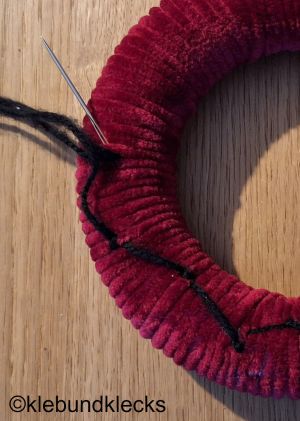 Muster aus Wolle auf Türkranz fädeln